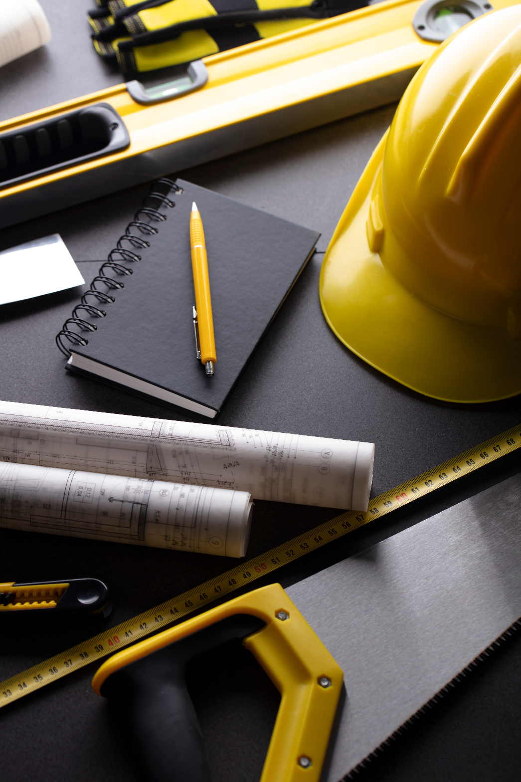 Construction safety equipment, plans, measuring tools, and a hard hat