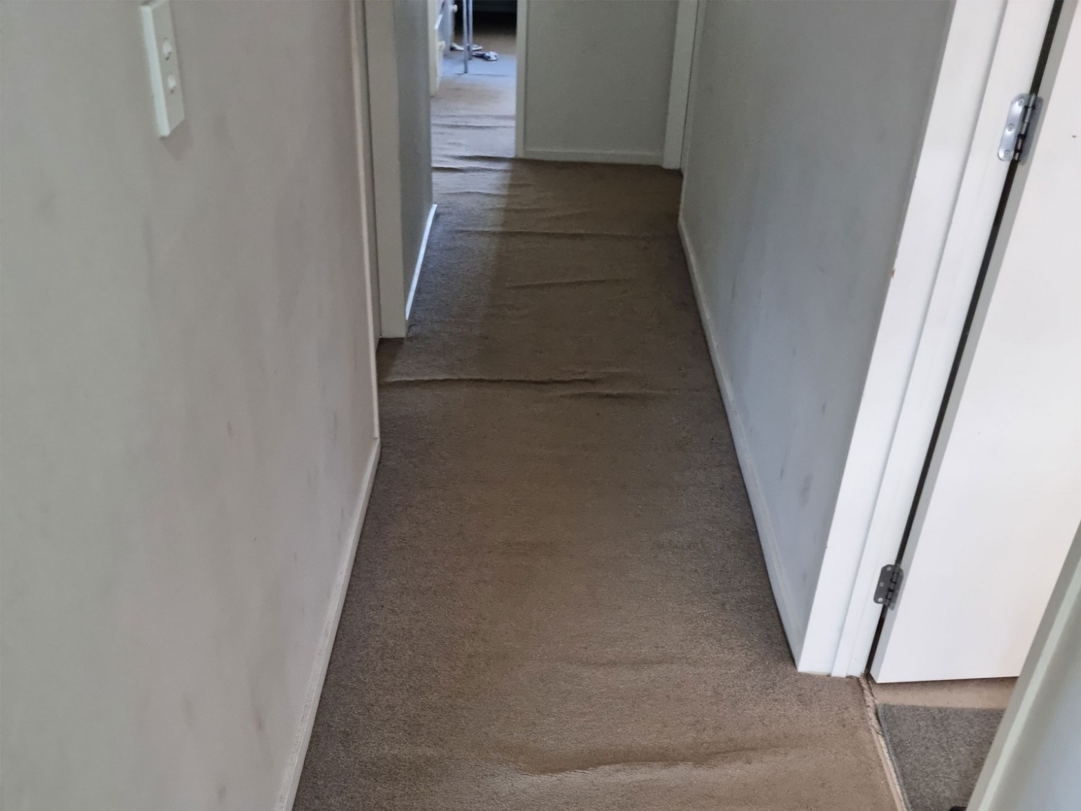 Rippled hallway carpet before restretching