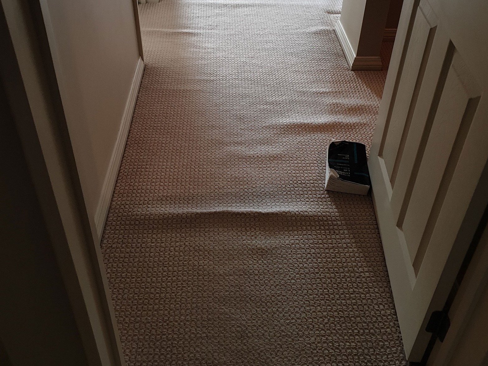 Rippled hallway carpet requiring restretching