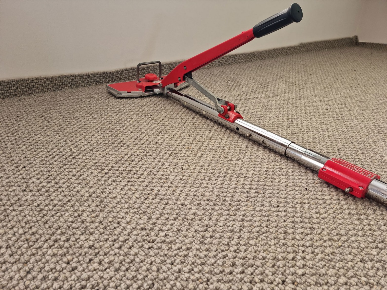 Power stretcher tool set up on rippled carpet before restretching