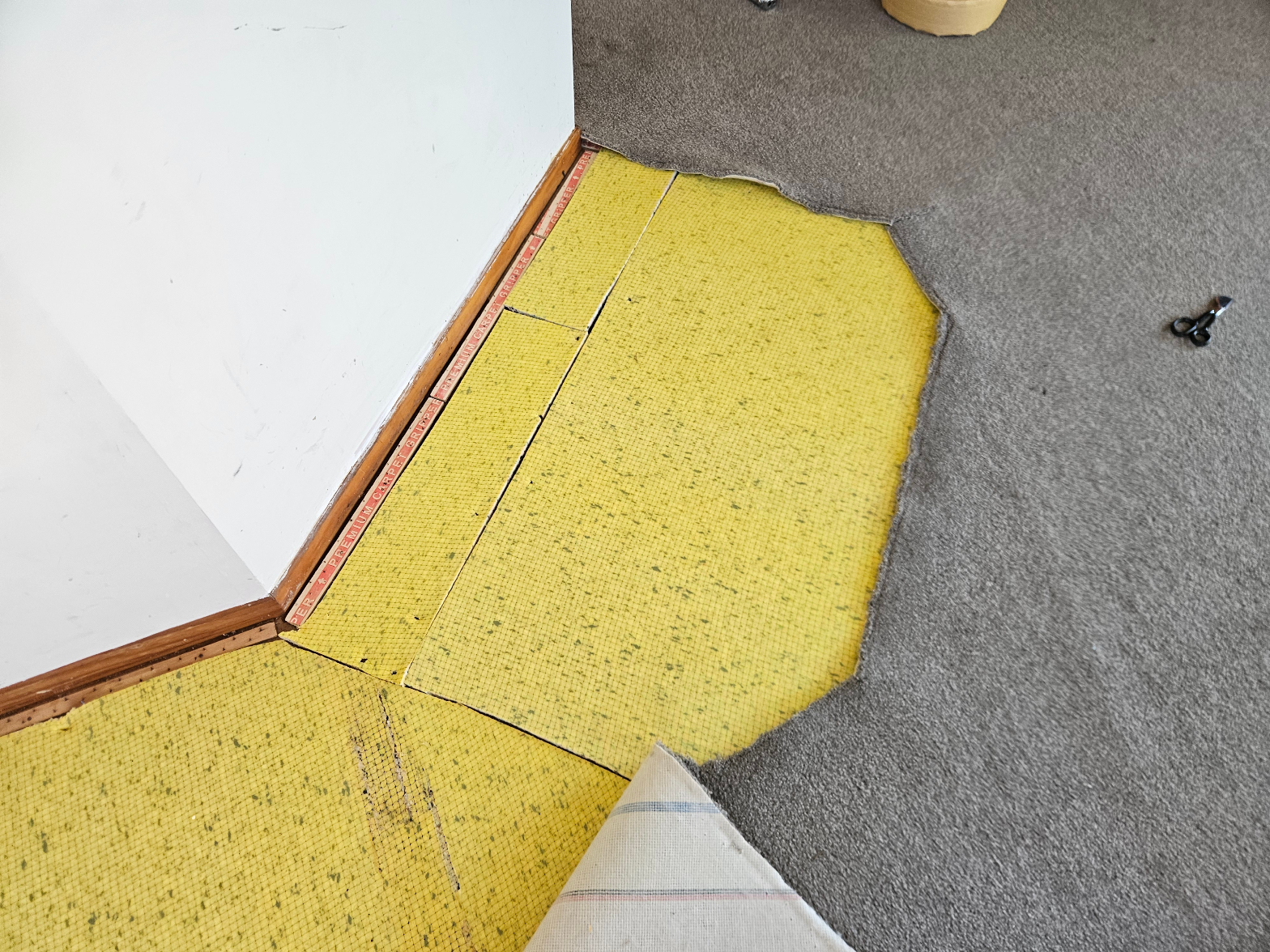 Carpet repair patch area prepared over yellow underlay