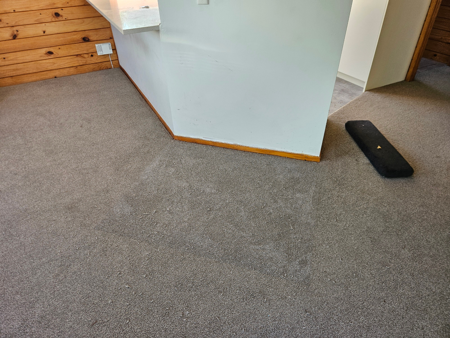 Grey carpet installed in room with wooden wall panelling