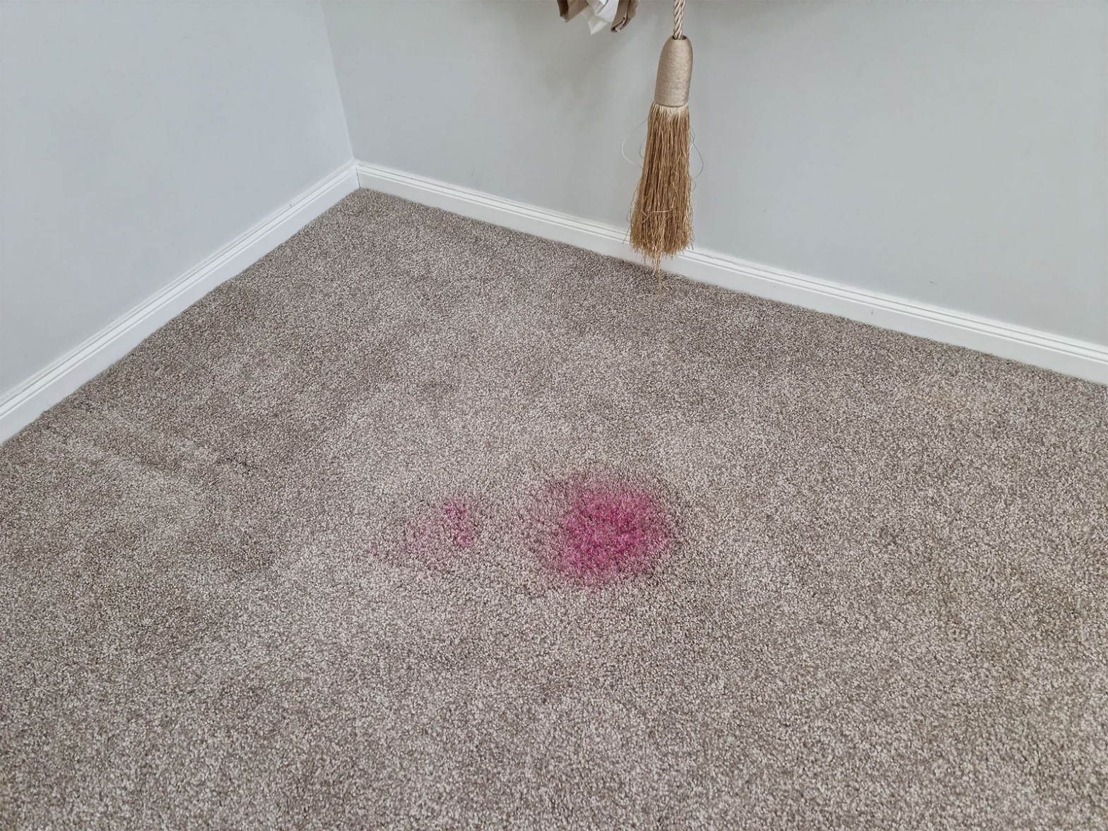 Grey carpet with pink stain before repair