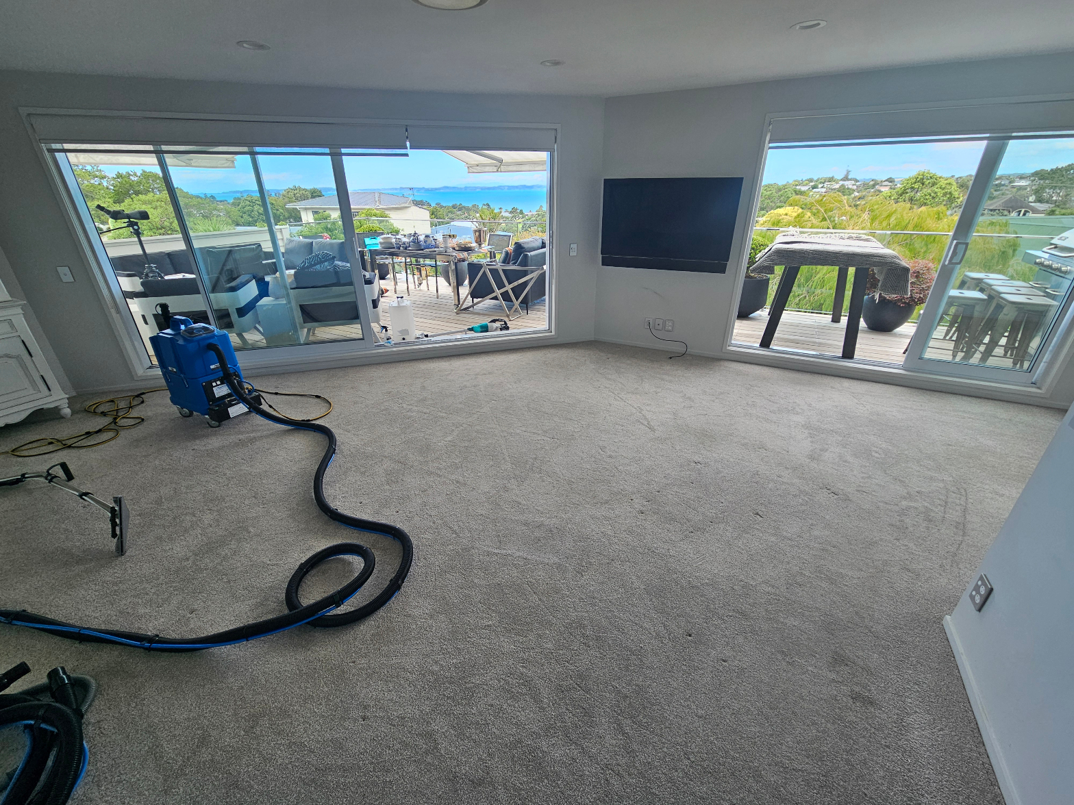 Professional carpet cleaning in progress – large open living room with sea views
