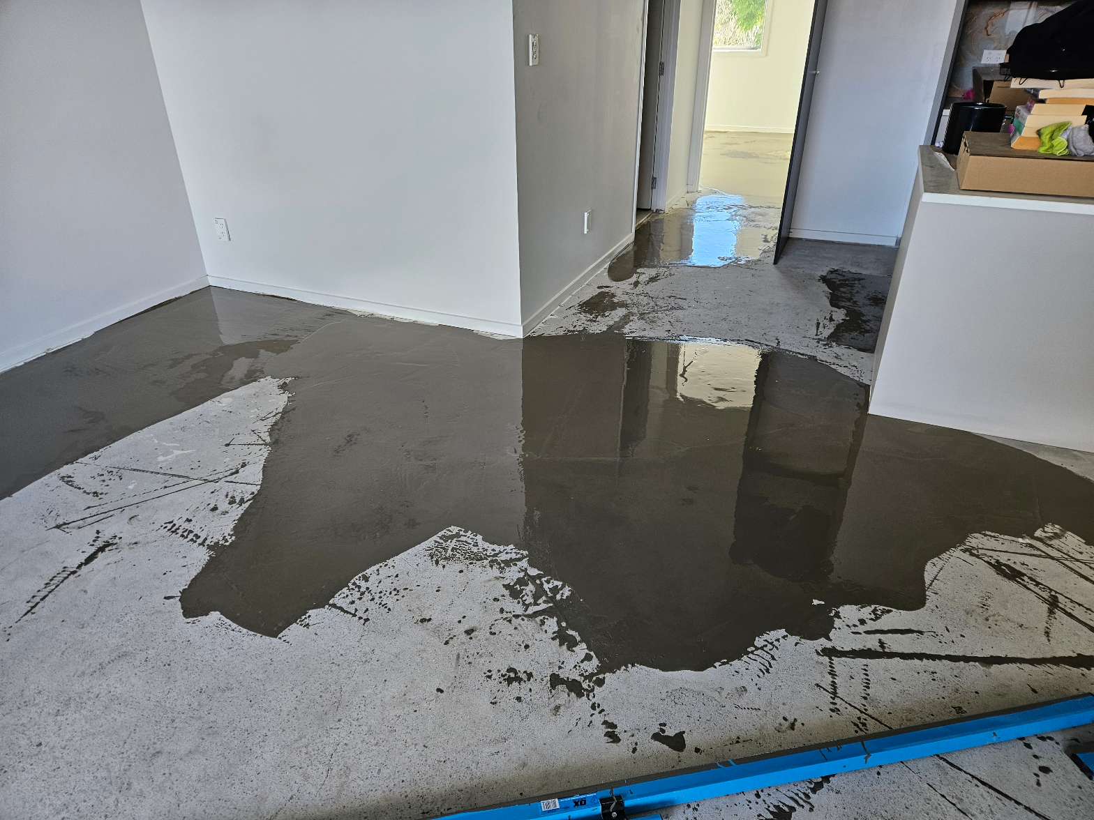 Self-levelling compound being applied to a concrete subfloor during floor preparation before laminate installation