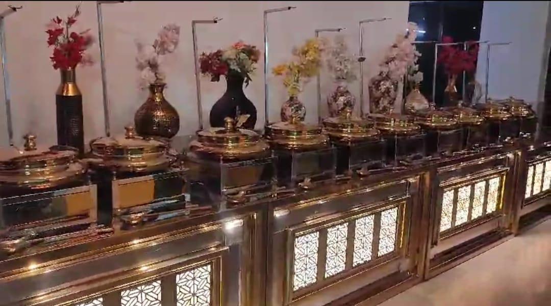 Elegant gold buffet setup with chafing dishes and decorative flower vases