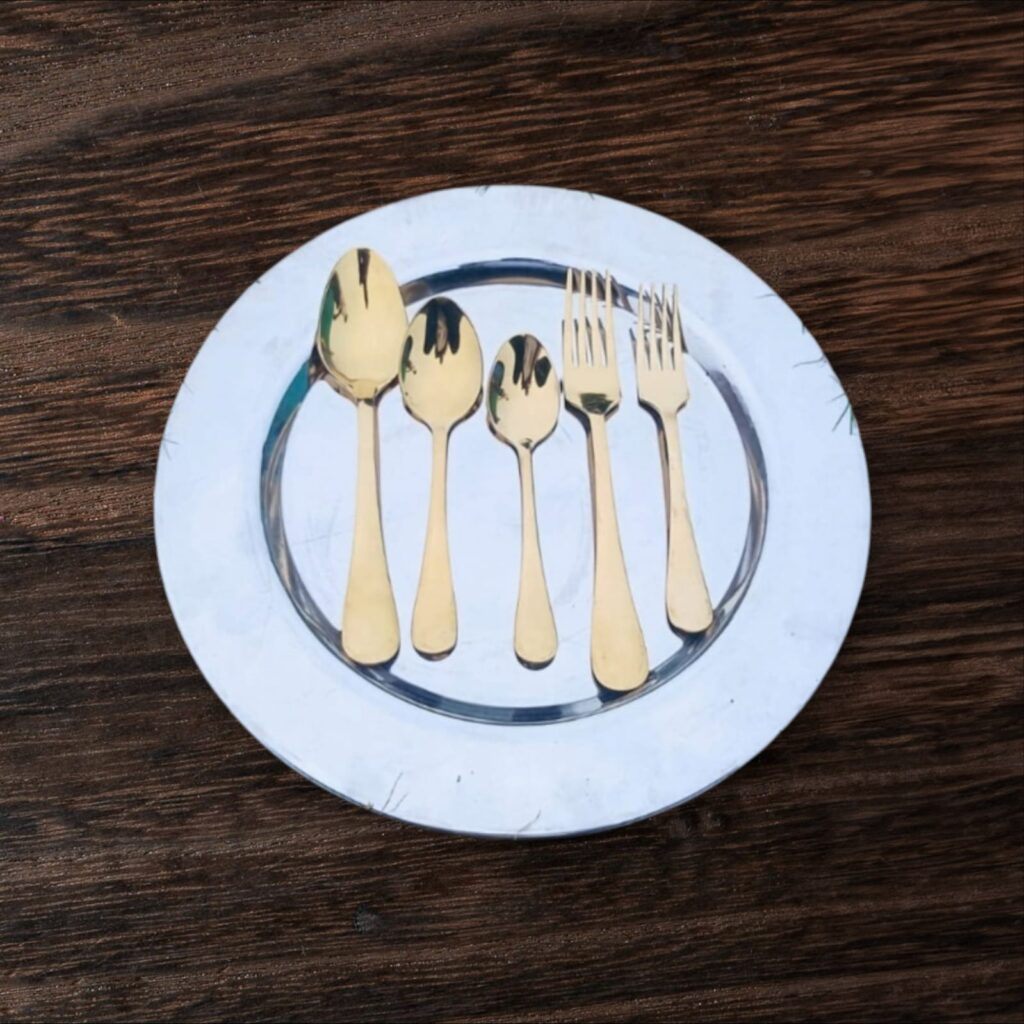 Gold cutlery place setting on marble plate